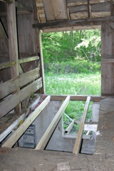 The floor was cut-out and reframed to make a solid platform to rebuild the wall.  The beam on the outside where the joists attach was replaced as well using existing barn material.